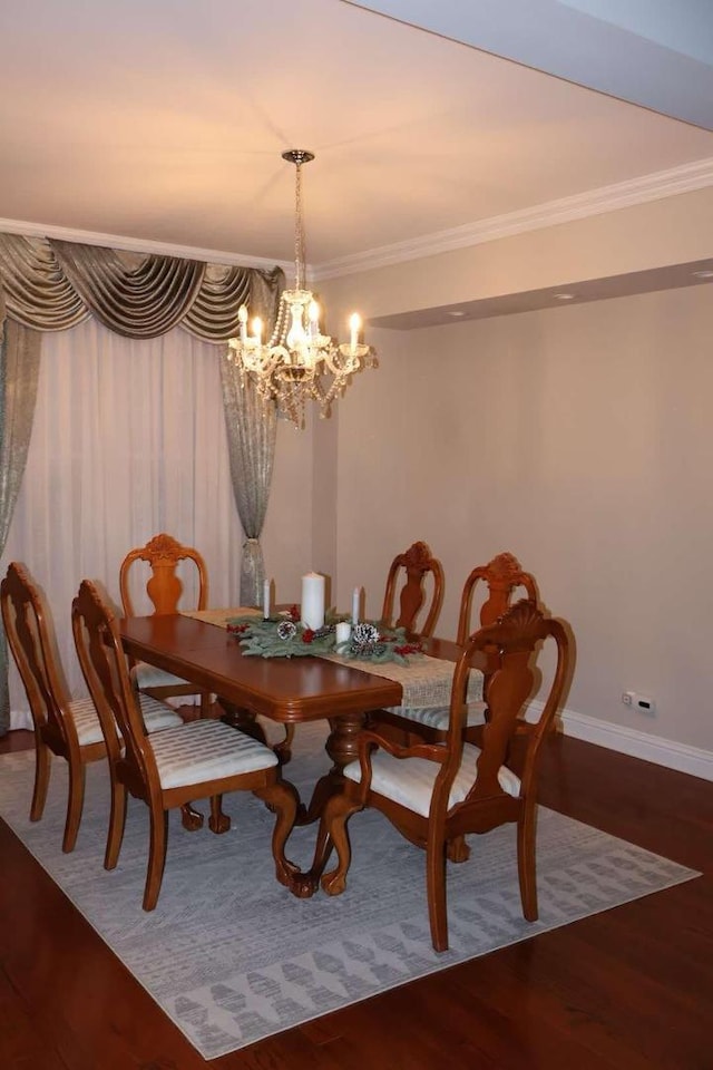 dining space with a chandelier, ornamental molding, wood finished floors, and baseboards