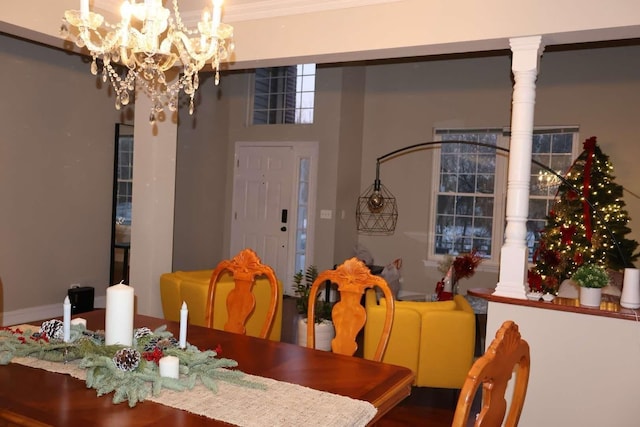 dining area featuring decorative columns and a notable chandelier