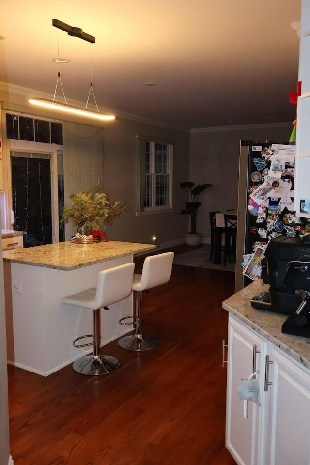 kitchen featuring freestanding refrigerator, dark wood-style flooring, and crown molding