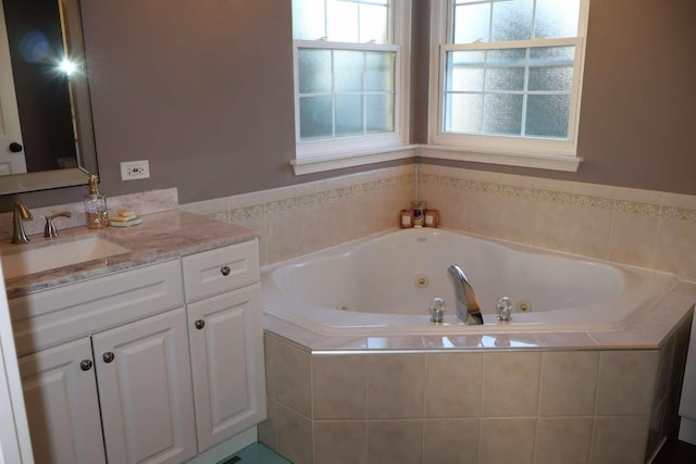 full bathroom with vanity and a tub with jets