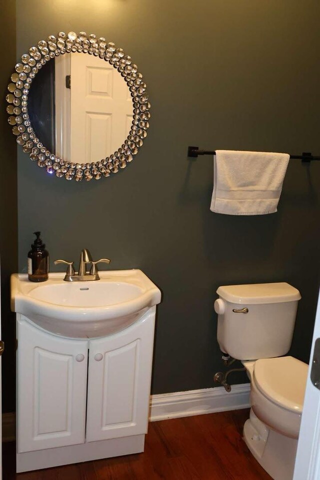 bathroom featuring vanity, wood finished floors, toilet, and baseboards