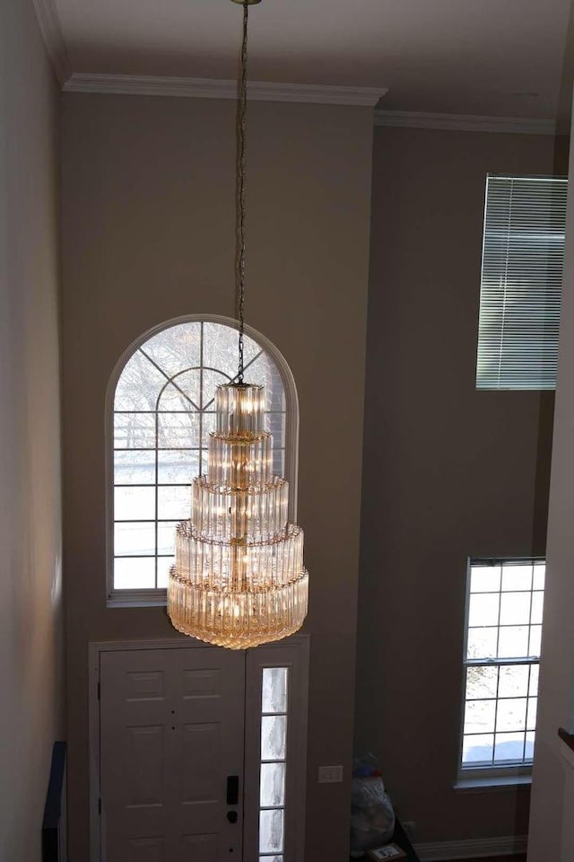 room details featuring visible vents, crown molding, and an inviting chandelier