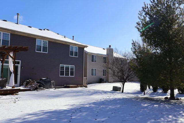 snow covered property with a pergola