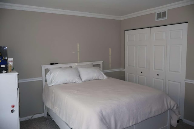 bedroom with a closet, visible vents, ornamental molding, carpet flooring, and baseboards