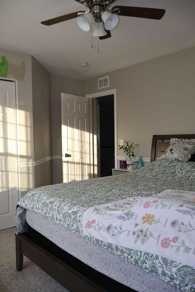 carpeted bedroom with visible vents and a ceiling fan