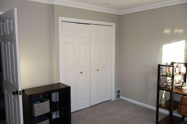 bedroom with carpet floors, a closet, crown molding, and baseboards