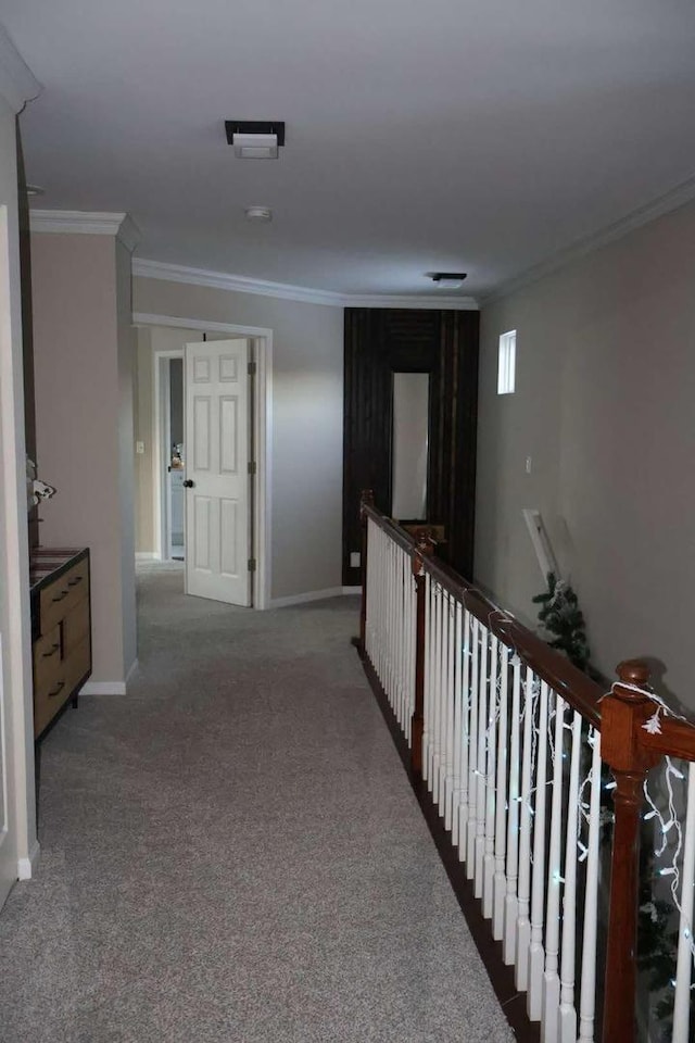 corridor with carpet floors, baseboards, and crown molding