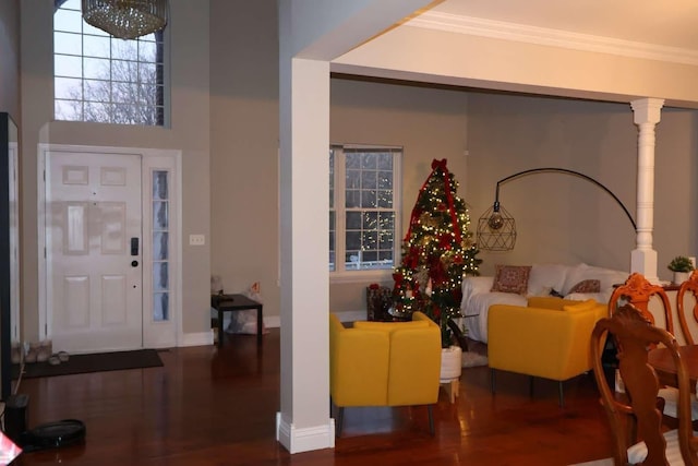 foyer entrance featuring ornamental molding, wood finished floors, and baseboards