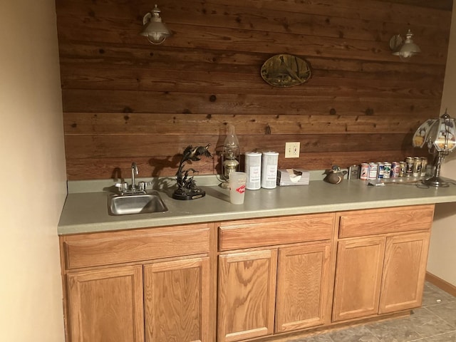 interior space featuring light countertops, a sink, and wooden walls