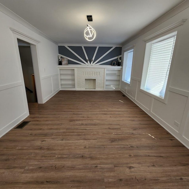 unfurnished living room featuring dark wood-style floors, visible vents, a fireplace, and a decorative wall