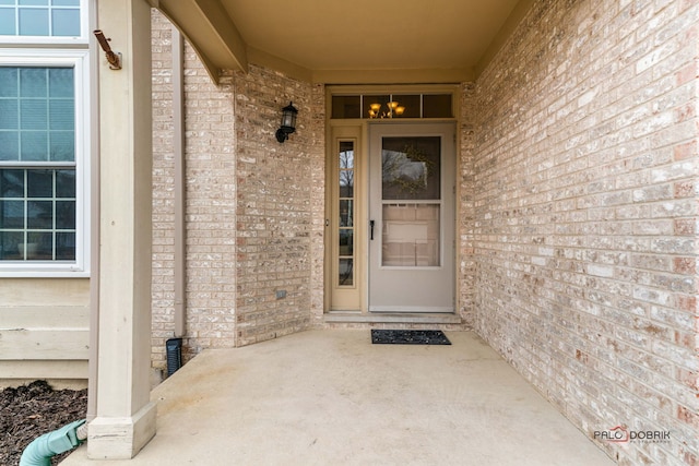 doorway to property with brick siding