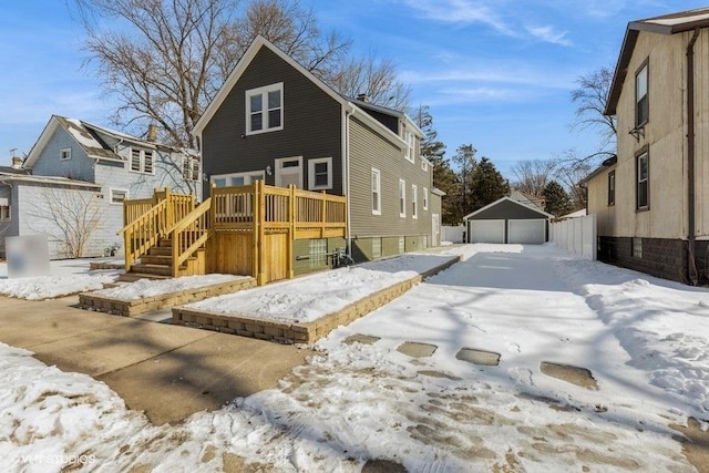 exterior space with a garage, a deck, stairway, and an outbuilding