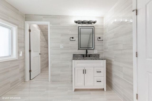 half bathroom featuring tile walls and vanity