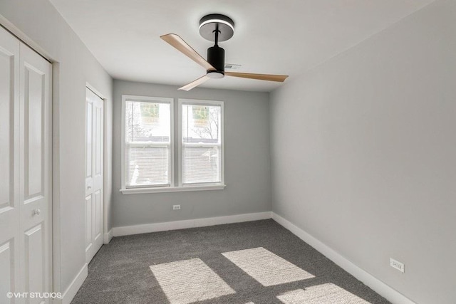 unfurnished bedroom featuring dark carpet, baseboards, and ceiling fan