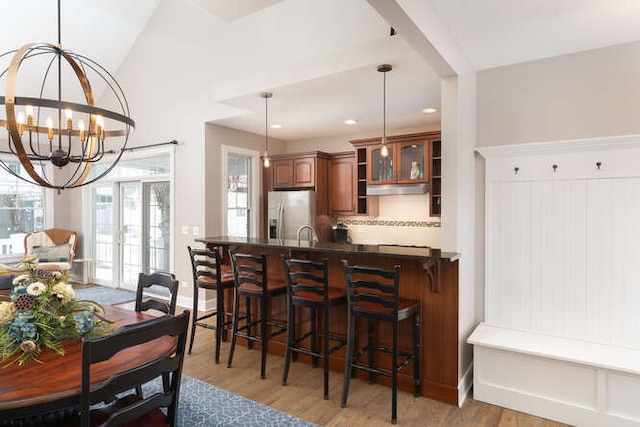 dining room with french doors, light wood finished floors, recessed lighting, a chandelier, and baseboards