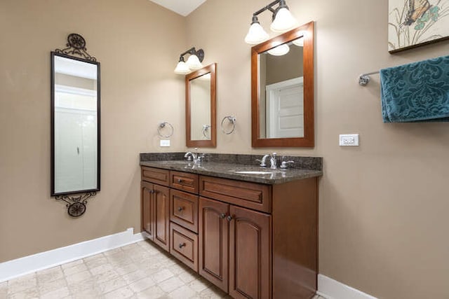 full bathroom featuring double vanity, tile patterned floors, a sink, and baseboards