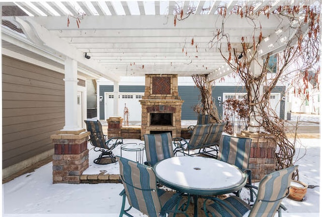 snow covered patio with an outdoor fireplace and a pergola