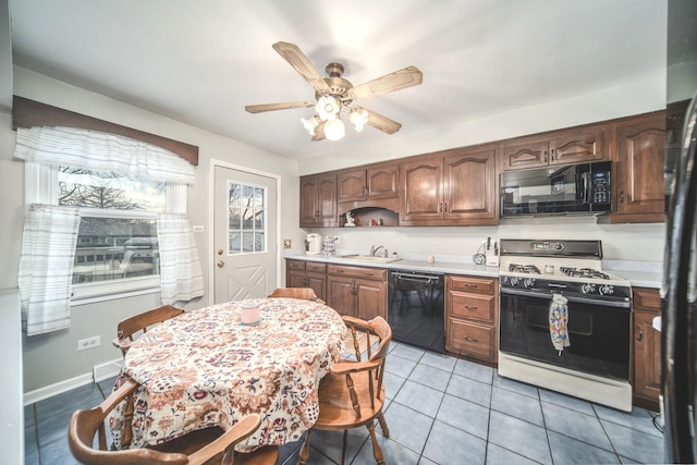 kitchen featuring light tile patterned floors, ceiling fan, light countertops, black appliances, and a sink