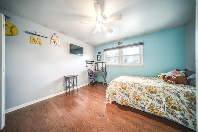 bedroom featuring wood finished floors, a ceiling fan, and baseboards