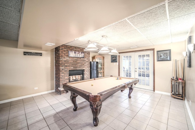 rec room with light tile patterned floors, a drop ceiling, visible vents, baseboards, and french doors