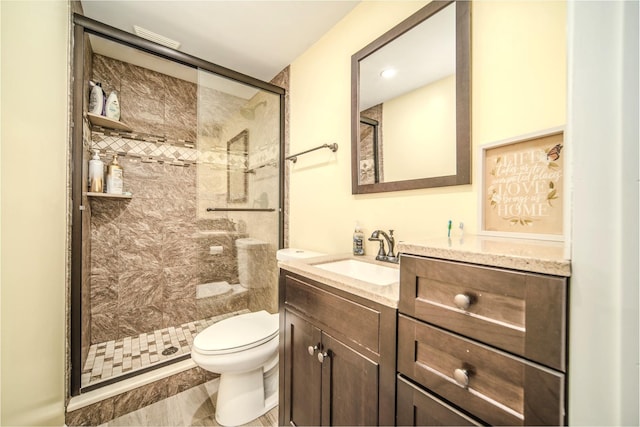 full bath featuring a stall shower, vanity, and toilet