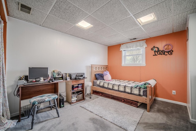 carpeted bedroom featuring a paneled ceiling, visible vents, and baseboards