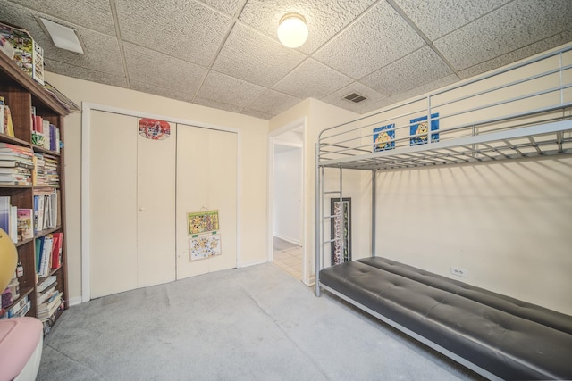 interior space with a paneled ceiling, a closet, and visible vents