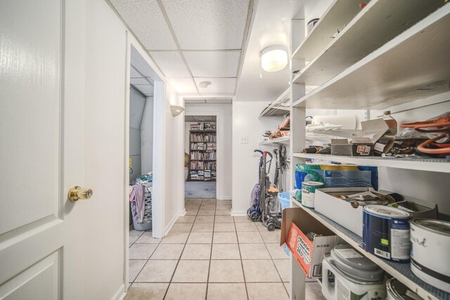 walk in closet with a drop ceiling and light tile patterned flooring