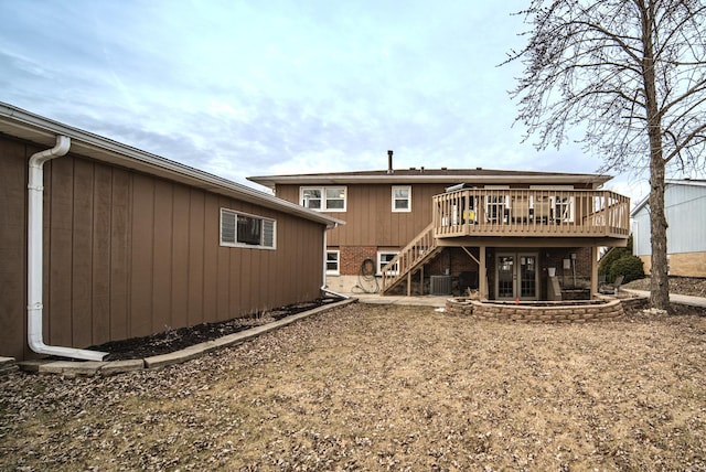 rear view of house with central AC unit, brick siding, stairway, and a wooden deck