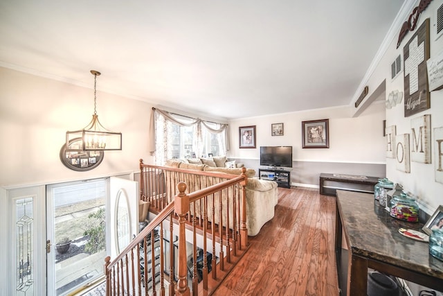 hallway with a chandelier, wood finished floors, an upstairs landing, and crown molding