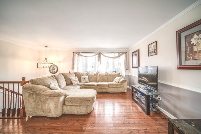 living area featuring a chandelier, crown molding, baseboards, and hardwood / wood-style flooring