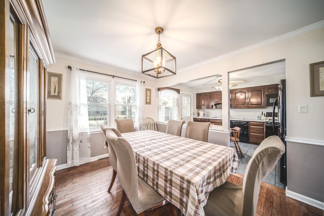 dining space with a notable chandelier, crown molding, baseboards, and hardwood / wood-style flooring