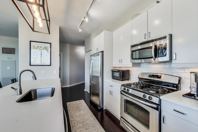 kitchen featuring stainless steel appliances, light countertops, visible vents, white cabinetry, and a sink