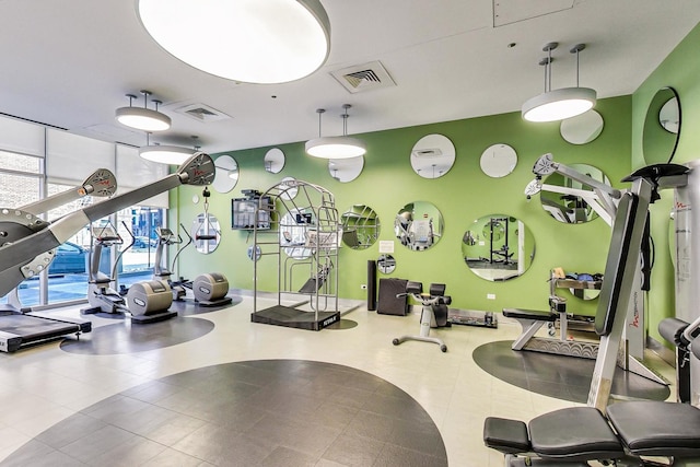 exercise room with visible vents and a wall of windows