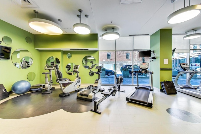 exercise room featuring expansive windows, visible vents, and plenty of natural light