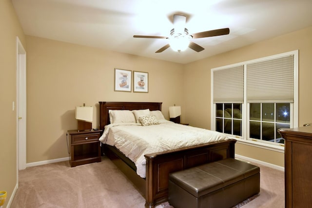 bedroom featuring ceiling fan, baseboards, and light colored carpet