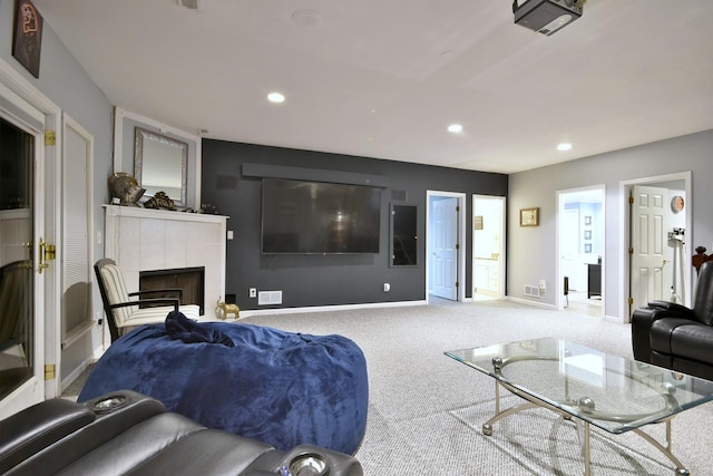 carpeted living area with visible vents, baseboards, a tiled fireplace, and recessed lighting