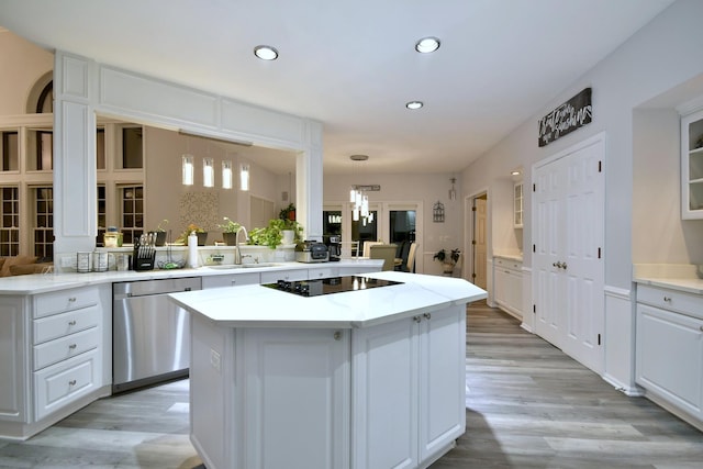 kitchen featuring white cabinets, a sink, light wood-type flooring, dishwasher, and black electric cooktop