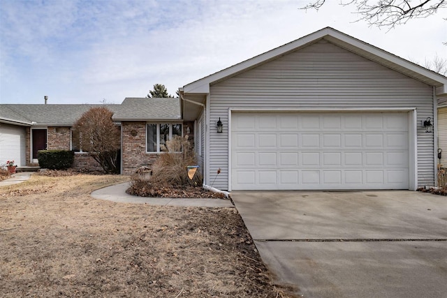 single story home featuring a garage, brick siding, and driveway