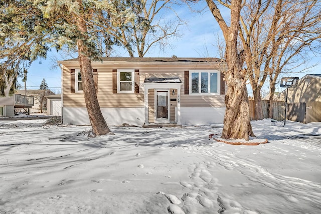 split foyer home featuring entry steps, a detached garage, and fence