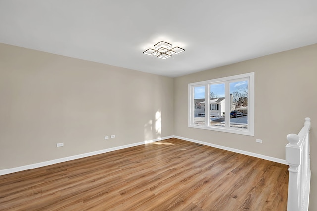 spare room featuring light wood finished floors and baseboards