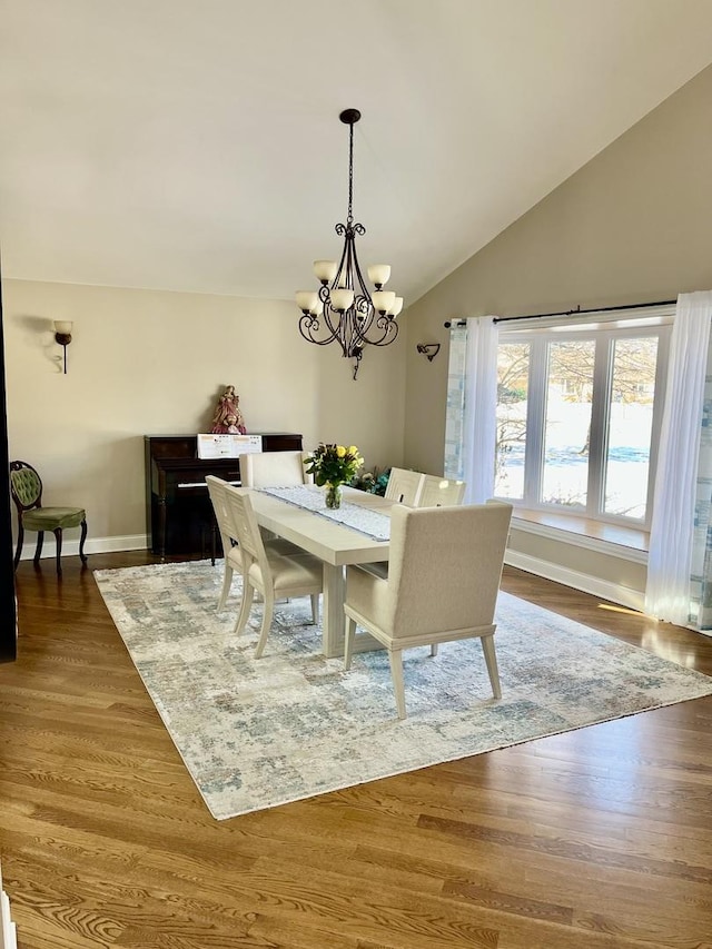 dining area with an inviting chandelier, baseboards, vaulted ceiling, and dark wood-type flooring