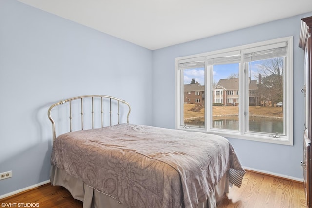 bedroom with wood finished floors and baseboards