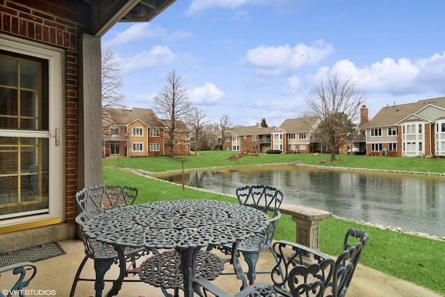 view of patio / terrace with a residential view and a water view