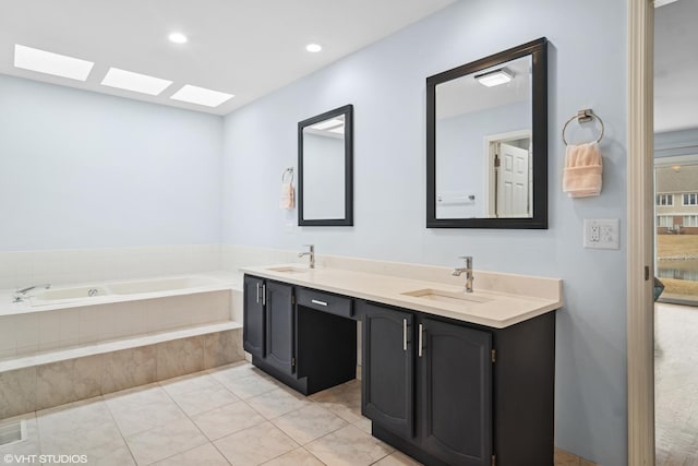 bathroom with tile patterned flooring, double vanity, a sink, and a bath