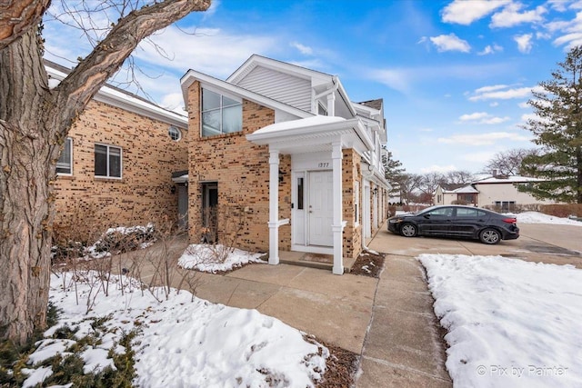 view of front facade featuring concrete driveway and brick siding