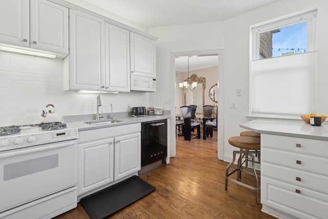 kitchen featuring light countertops, backsplash, white cabinets, a sink, and white appliances