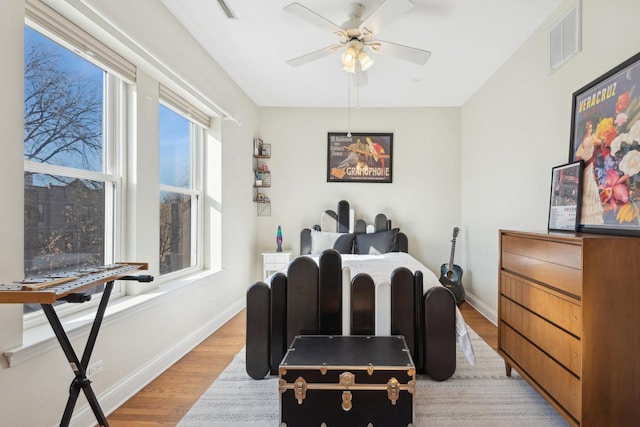 dining space featuring baseboards, visible vents, ceiling fan, and light wood finished floors