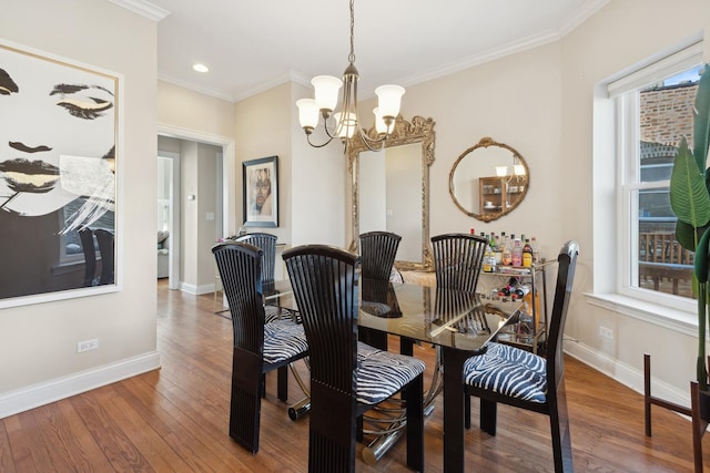 dining room featuring baseboards, a chandelier, wood finished floors, and crown molding