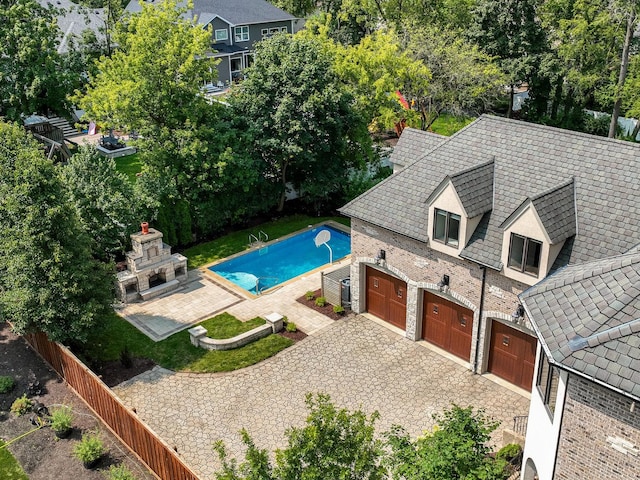 view of swimming pool with a fireplace and fence